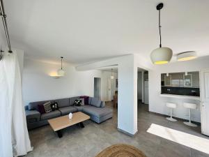 a living room with a couch and a table at Seaview & Jacuzzi Villa Sea View in Mikonos