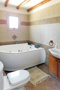 ein Badezimmer mit einer Badewanne, einem WC und einem Waschbecken in der Unterkunft Lianti in Pomos