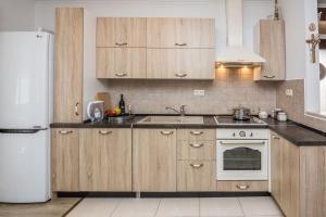 a kitchen with wooden cabinets and a white refrigerator at Apartment Velika obala in Bibinje