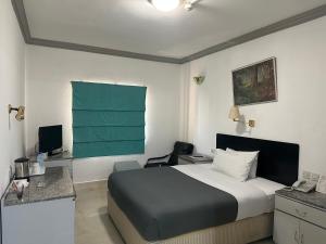 a bedroom with a bed and a desk with a computer at Grand Astoria Hotel in Dubai