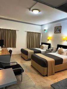 Cette chambre comprend 2 lits et une table. dans l'établissement Grand Astoria Hotel, à Dubaï