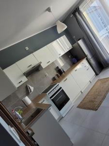 widok na kuchnię z białymi urządzeniami w obiekcie Apartament Słowińców 42 w Wejherowie