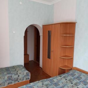 1 dormitorio con 2 camas y armario de madera en Готель-хостел en Truskavets