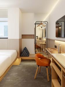 a bedroom with a bed and a desk and a mirror at ASAI Bangkok Sathorn in Bangkok
