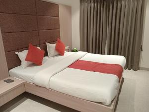 a bedroom with a large bed with red pillows at Hotel Rajshree in Ahmadnagar
