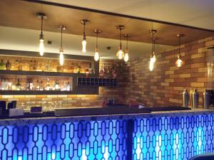 a bar with blue lights on a brick wall at Hotel Rajshree in Ahmadnagar