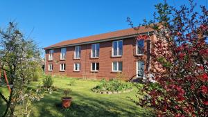 a large brick building with a garden in front of it at Haus Schmidt in Alt Bukow