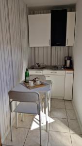 eine kleine Küche mit einem Tisch und Stühlen sowie einem TV in der Unterkunft Haus Schmidt in Alt Bukow