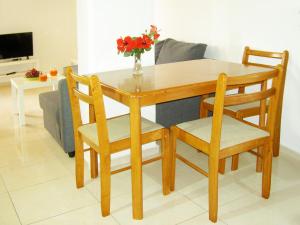 une table en bois avec deux chaises et un vase de fleurs dans l'établissement Mat Old Town Apartments B, à Réthymnon