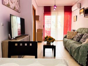 a living room with a couch and a tv at Hermoso y Acogedor bien situado in Oropesa del Mar