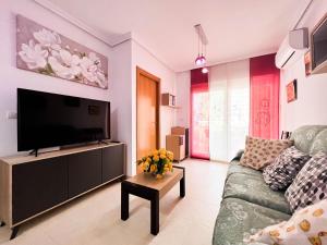 ein Wohnzimmer mit einem Sofa und einem Flachbild-TV in der Unterkunft Hermoso y Acogedor bien situado in Oropesa del Mar