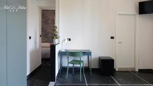 a blue table and a green chair in a room at Hotel Le Palme in Varazze