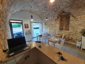 a kitchen and living room with a laptop on a desk at Il Daviduccio ibla in Ragusa