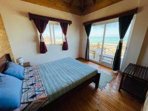 Schlafzimmer mit einem Bett und Meerblick in der Unterkunft Kokoa Sands - Ankasy Madagascar in Tsiandamba