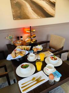 una mesa con comida para el desayuno y bebidas en ella en Villa La Dune - Ontbijt & parking inclusief, en Middelkerke