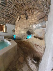 a bathroom with a stone wall and a bath tub at Il Daviduccio ibla in Ragusa