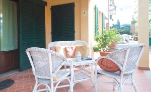 twee rieten stoelen en een tafel op een veranda bij I Borghi in San Gimignano