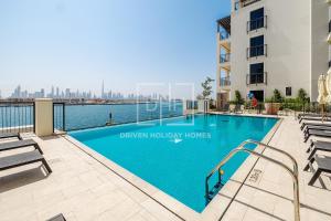 a swimming pool with a view of the city at Magnificent Sea Views 1 Bedroom at View Le Pont B1 La Mer, Dubai in Dubai