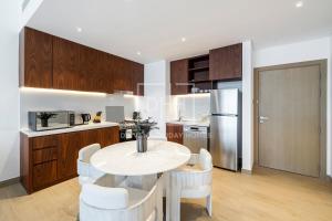 a kitchen with a white table and white chairs at Magnificent Sea Views 1 Bedroom at View Le Pont B1 La Mer, Dubai in Dubai