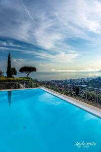 una gran piscina azul con vistas a la ciudad en Villa Gaia - Luxury Villa, pool & wellness rooms, en Bordighera