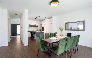 ein Esszimmer mit einem Tisch und grünen Stühlen in der Unterkunft 5 Bedroom Amazing Home In Podstrana in Podstrana
