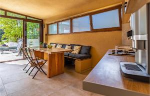 eine Küche und ein Wohnzimmer mit einem Tisch und einem Sofa in der Unterkunft Nice Home In Betiga With Sauna, Outdoor Swimming Pool And Jacuzzi in Barbariga