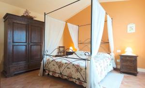een slaapkamer met een hemelbed en een houten kast bij I Borghi in San Gimignano
