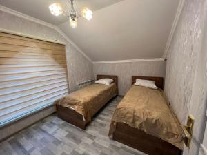 2 camas en una habitación con persianas en VILLA MEYSARY, en Şamaxı