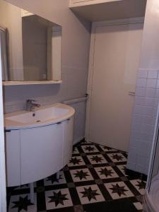 y baño con lavabo y espejo. en L'appart de Babou REZ DE CHAUSSEE parking free draps wifi, en Thiers