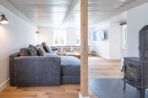 uma sala de estar com um sofá e um fogão a lenha em Ferien unter Reet em Ostenfeld