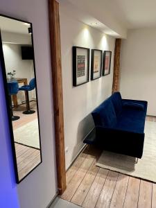a living room with a blue couch and a mirror at Stilvolles Apartment mit Sauna in Burg