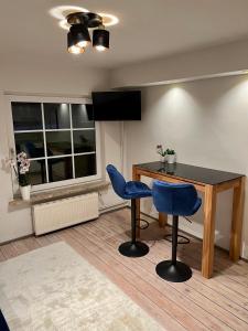 a dining room with a table and two blue chairs at Stilvolles Apartment mit Sauna in Burg