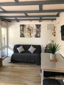 ein Wohnzimmer mit einer schwarzen Couch in einem Zimmer in der Unterkunft Village Vacances aux Villages sous les Pins in Léon