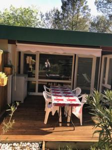 ein Haus mit einem Tisch und Stühlen auf einer Terrasse in der Unterkunft Village Vacances aux Villages sous les Pins in Léon