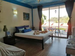 a bedroom with a large bed and a balcony at Hotel de la Plage in Kep