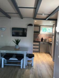 eine Küche und ein Esszimmer mit einem Tisch in der Unterkunft Village Vacances aux Villages sous les Pins in Léon
