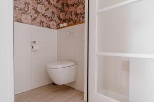 a bathroom with a toilet and a shower at Duinvilla Aan de Zee B&B in Zoutelande