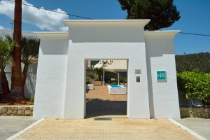a white house with a door in a yard at Hotel Rural Can Maries in Puerto de San Miguel