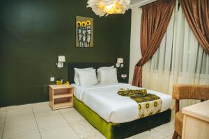 Un dormitorio con una cama grande y una lámpara de araña. en Amata n'Ubuki Boutique Hotel en Kigali