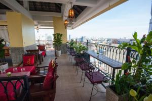 a restaurant with a balcony with tables and chairs at Khmer Surin Boutique Guesthouse in Phnom Penh