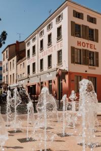 a water fountain in front of a hotel at Mage hôtels - Hôtel la grenette in Roanne
