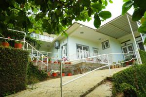 a white house with a porch and a driveway at Copperhill- A Luxury Homestay in Madikeri