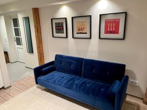 un sofá azul en una sala de estar con fotos en la pared en Stilvolles Apartment mit Sauna, en Burg