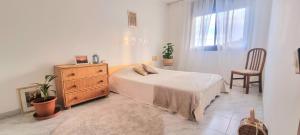 托德拉的住宿－Can Domenech Montnegre，一间卧室配有一张床、梳妆台和椅子