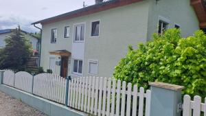 a white picket fence in front of a house at Come a casa in Nikelsdorf