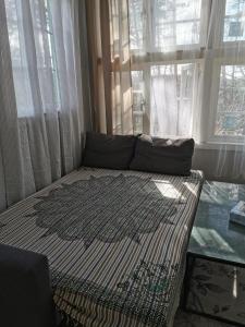 Bett in einem Zimmer mit einem großen Fenster in der Unterkunft Lilla stugan in Göteborg