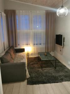 uma sala de estar com um sofá, uma televisão e uma mesa em Lilla stugan em Gotemburgo