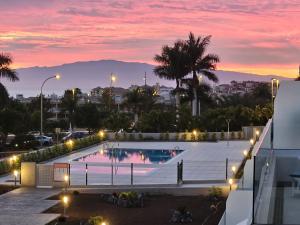 a view of a swimming pool at night at Costa Adeje Ocean View Apartment in Adeje