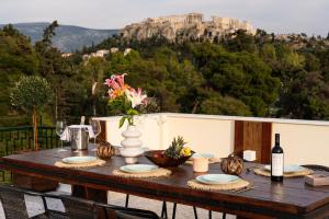 a wooden table with a vase of flowers on it at Visum Acropol ,3BR - Private Terrace-Jacuzzi - Amazing View in Athens