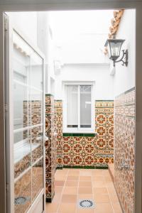 a bathroom with a shower and a tile wall at Apartamentos Casa Tuli A, ALJARAQUE in Aljaraque